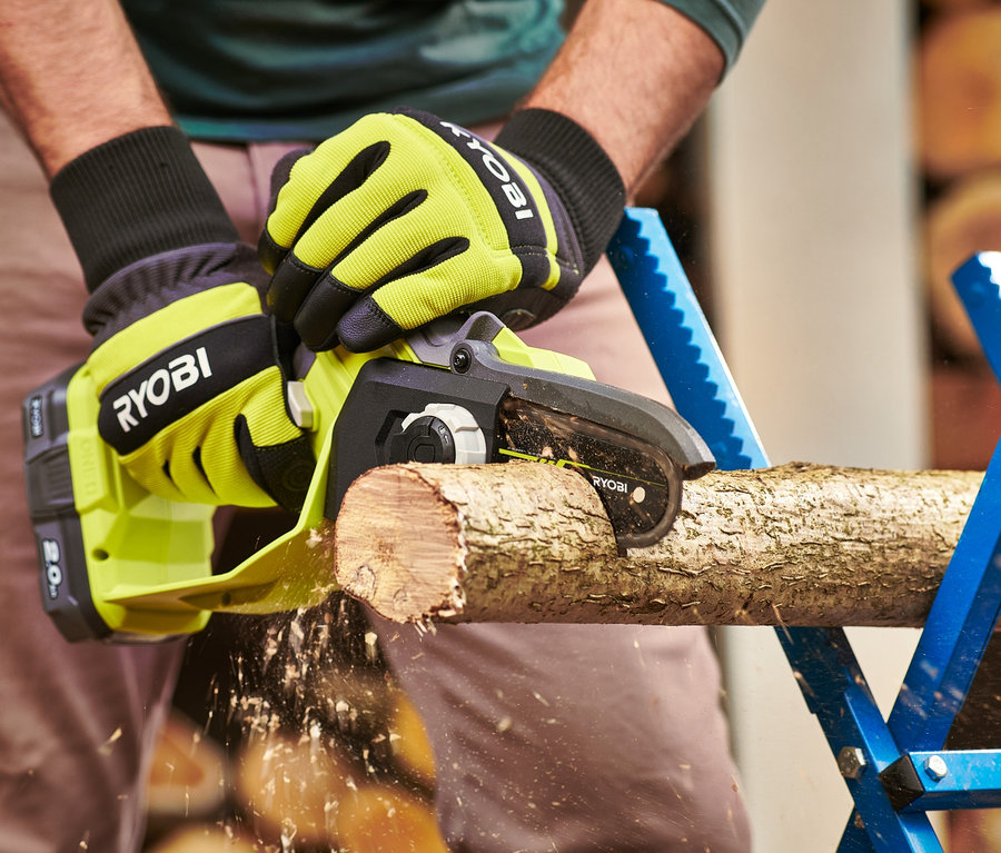Mann sägt ein Stück Holz mit einer RYOBI 18 V One+ Brushless Akku-Einhand-Kettensäge.