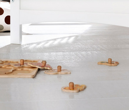 Holzpuzzle liegt unter einem weißen Bett auf dem Boden. Zu sehen ist ein 3-teiliges Pinolino Set »Florentina« extrabreit.