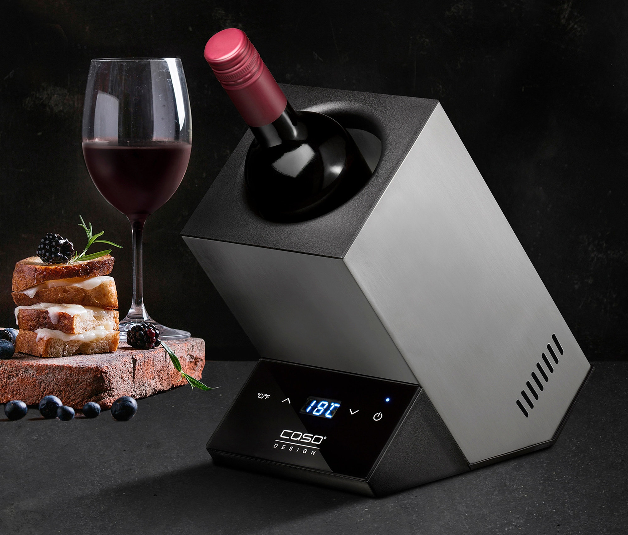 Eine Flasche Wein im CASO Weinkühler »Wine Case One« neben einem Glas Wein und Snacks.