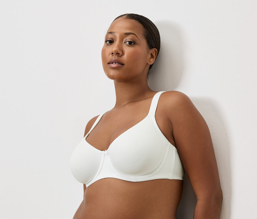 Porträt einer Frau mit brauner Haut in einem weißen BH.
