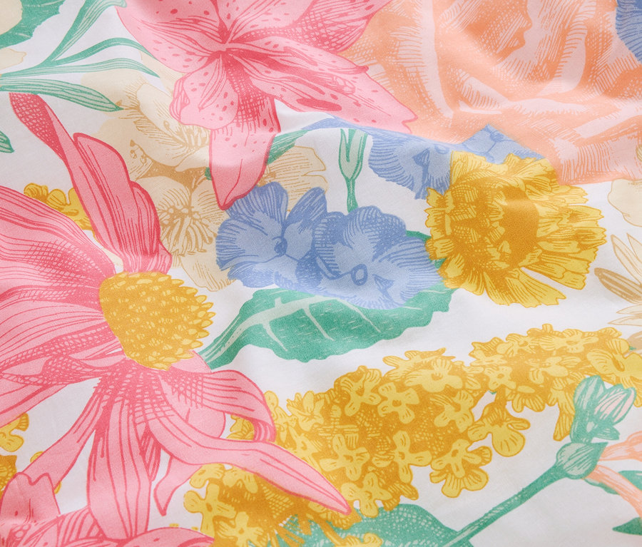 Nahaufnahme von Stoff mit rosa, gelben und blauen Blumenmuster.