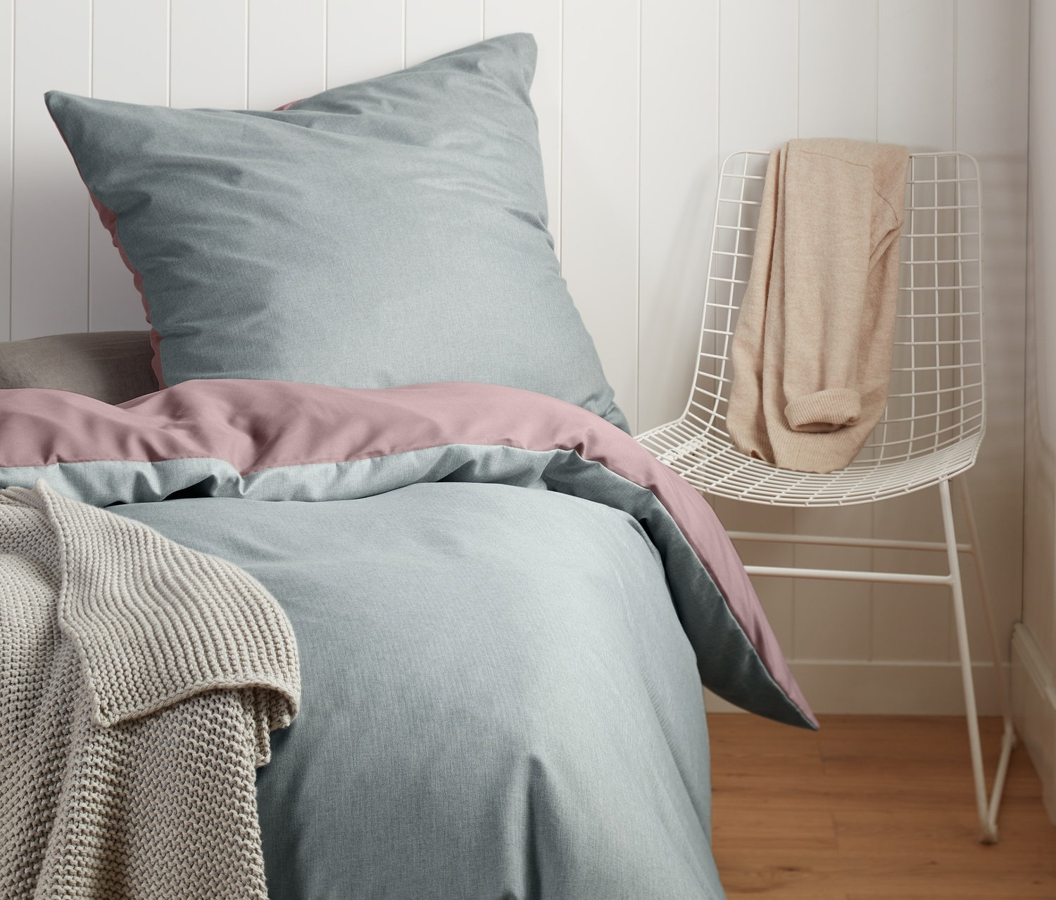 Schlafzimmer mit Microfaser-Flanell-Bettwäsche in Doppelgröße und Normalgröße, ergänzt durch eine Decke und einen Stuhl.