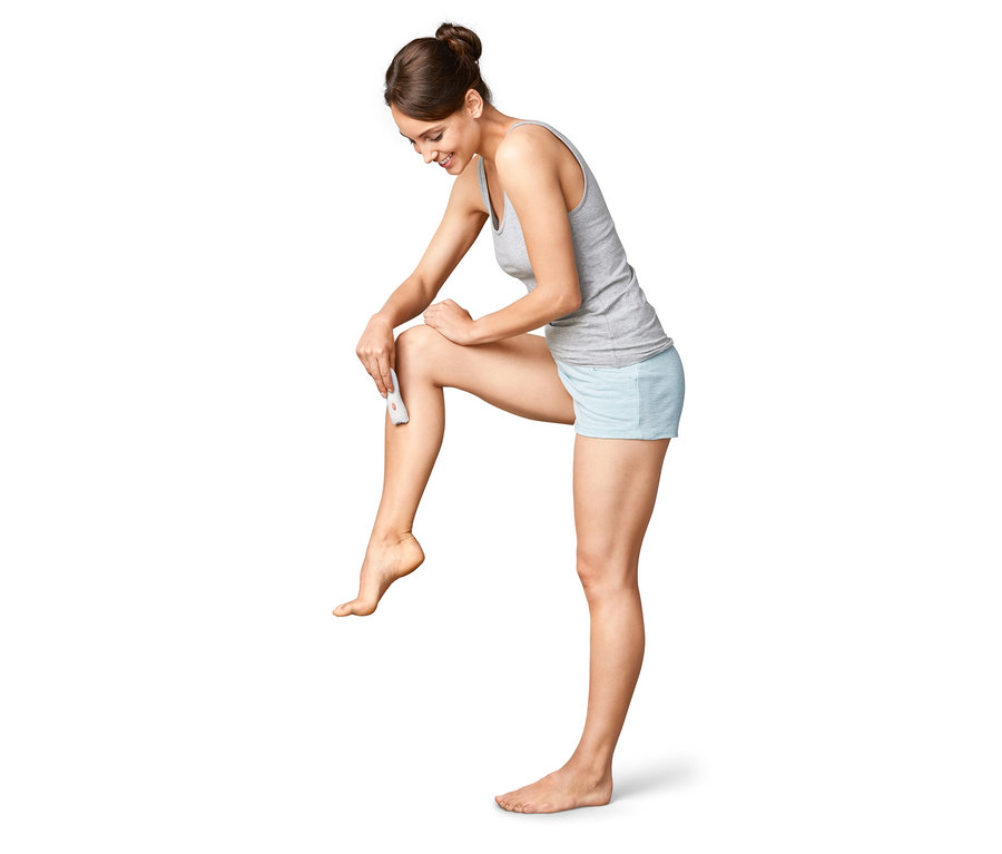 Frau verwendet einen Gesichtsepilierer an ihrem Bein.