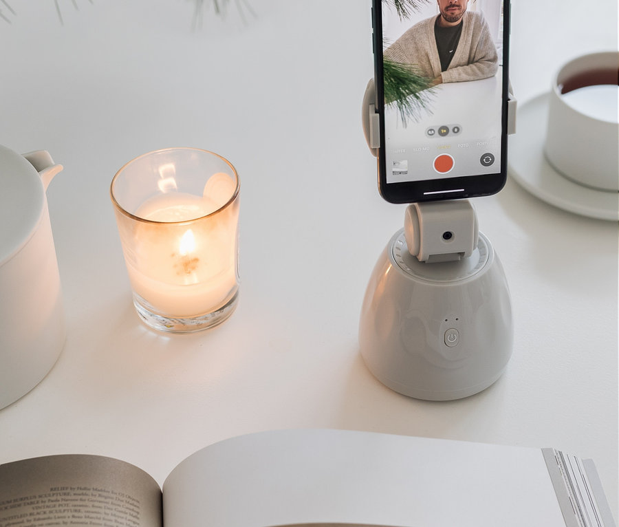 Ein Handy befindet sich in einer Handyhalterung mit Bewegungssensor. Auf dem Bildschirm des Handys ist ein Mann zu sehen.