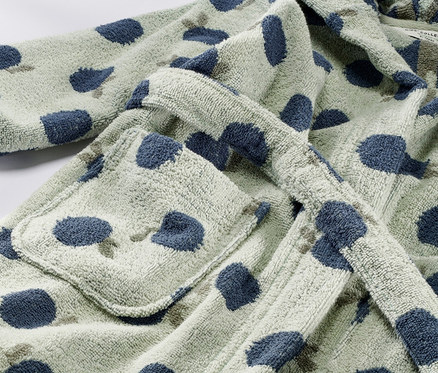 Detailansicht eines Kinder-Bademantels mit blauen Tupfen.