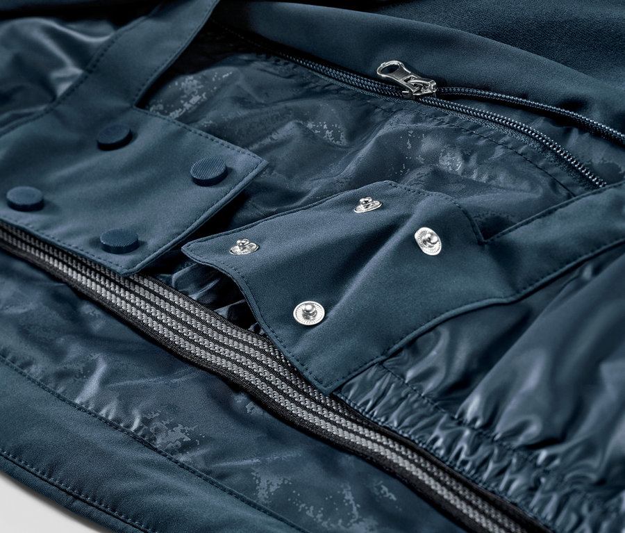 Detailaufnahme einer marineblauen Skijacke mit Reißverschluss und Knöpfen.
