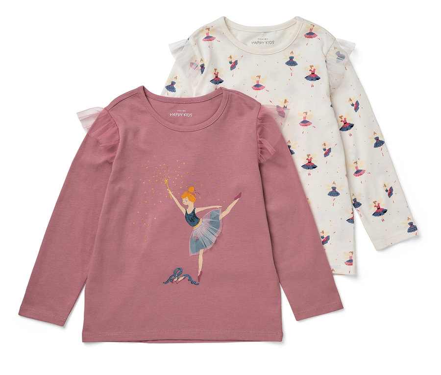 Zwei Kinder-Langarmshirts mit Tüll-Rüschen liegen übereinander. Das eine ist rosa mit einer Ballerina, das andere ist weiß mit einem Feenmuster.