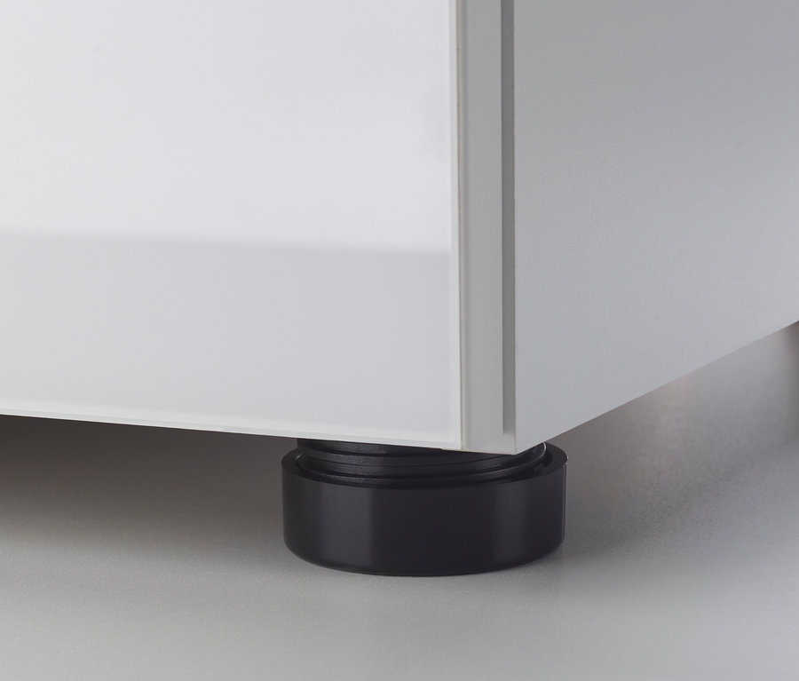 Detail eines weißen Möbelstücks mit einem schwarzen Fuß.