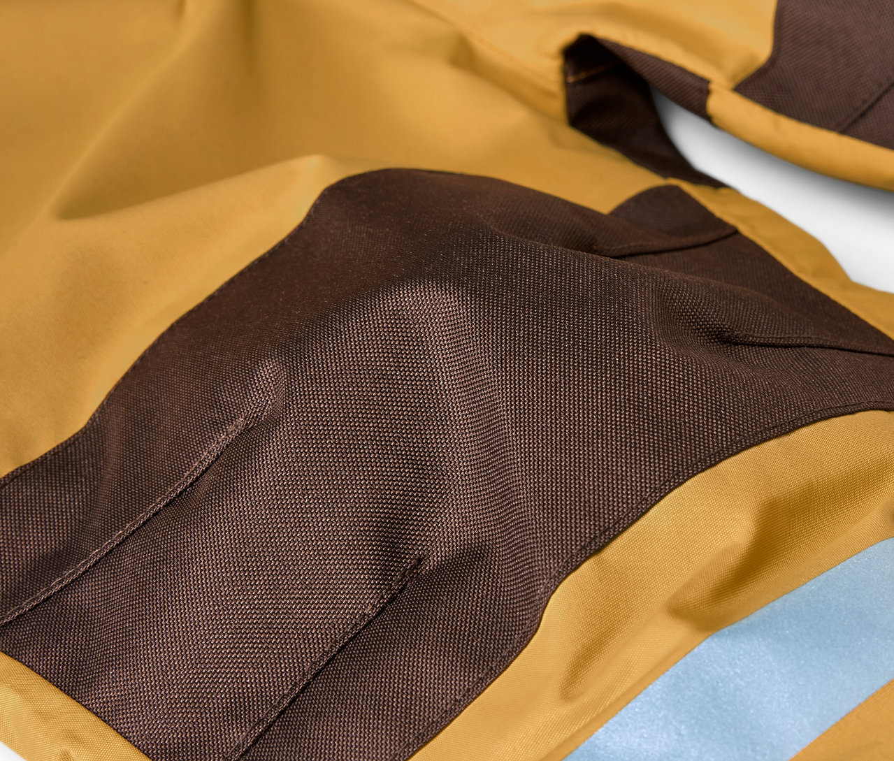 Detailansicht eines Kinder-Regen-Einteilers in Braun und Ocker.