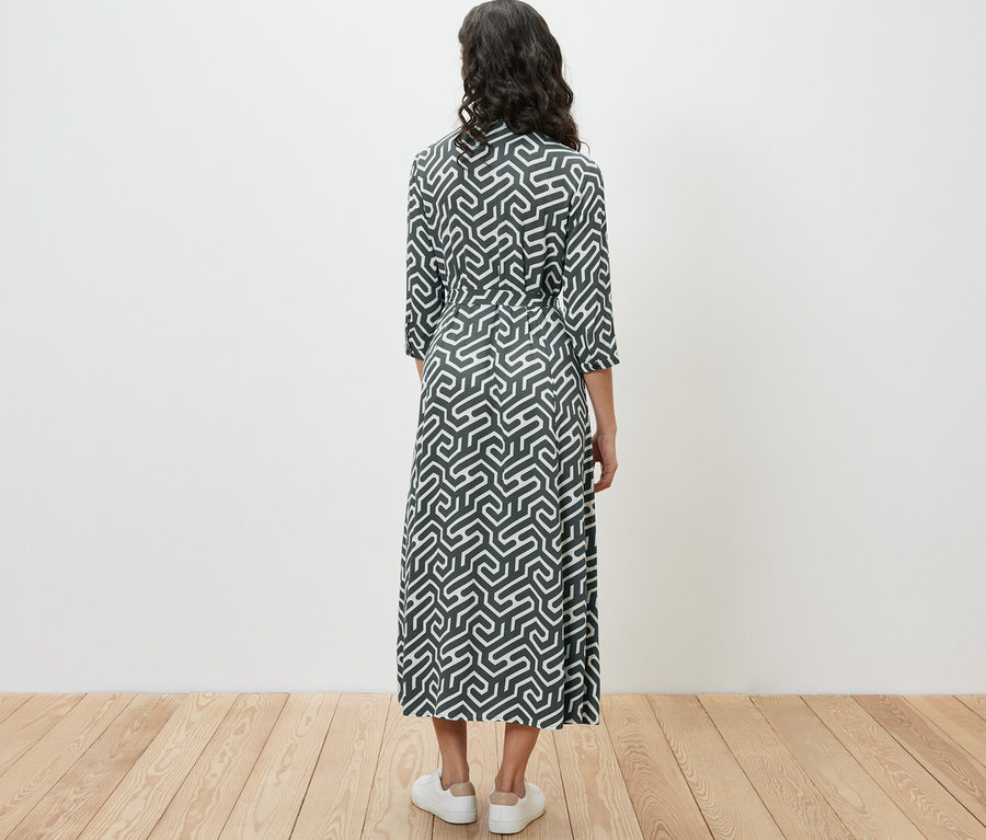 Frau von hinten in einem bedruckten Hemdblusenkleid.