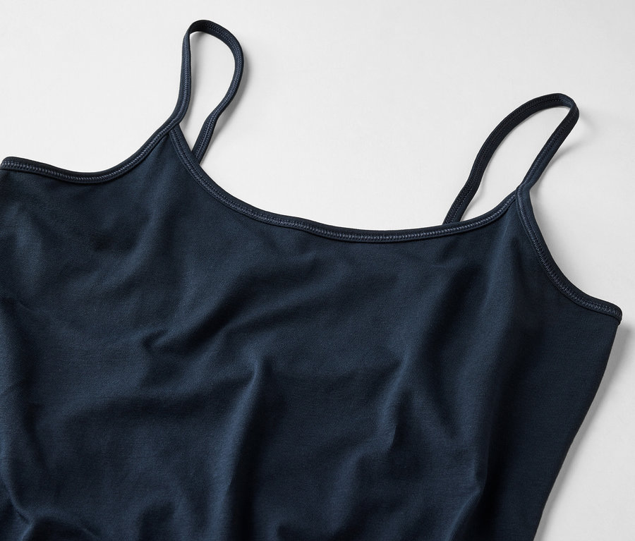 Nahaufnahme eines dunkelblauen Damen-Tanktops mit dünnen Trägern auf hellem Hintergrund.