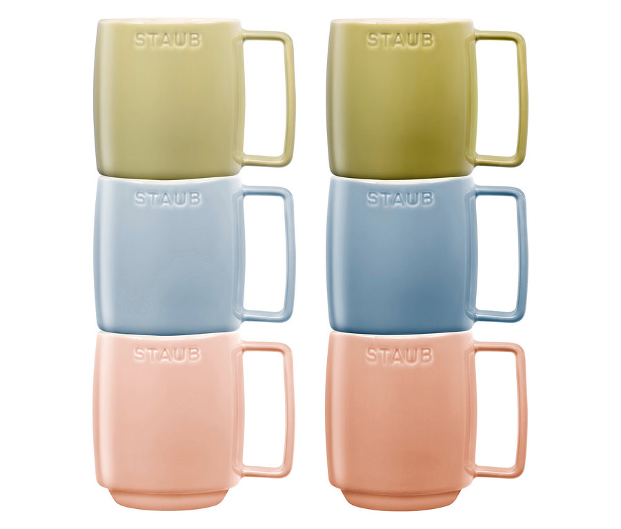 Sechs STAUB Kaffeebecher »Macaron« in Gelb-, Blau- und Rosatönen sind paarweise gestapelt.