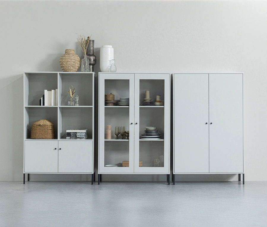 Drei graue Schränke unterschiedlicher Größe stehen nebeneinander an einer Wand.