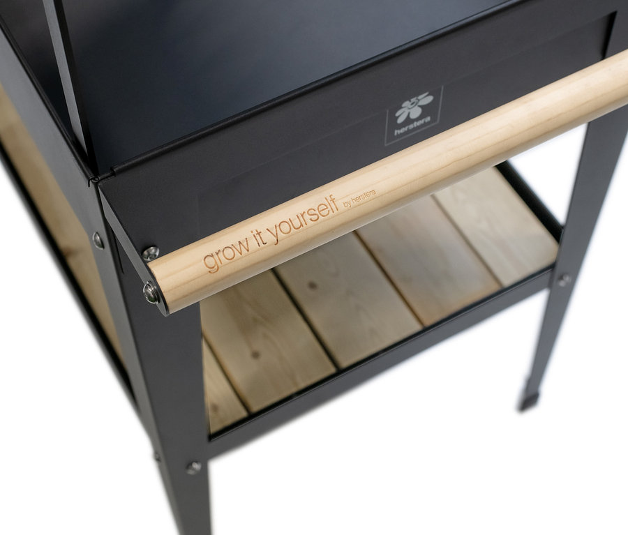 Detailansicht einer schwarzen Kräuterfabrik »Urban Expert« mit Holzgriff und Ablage.