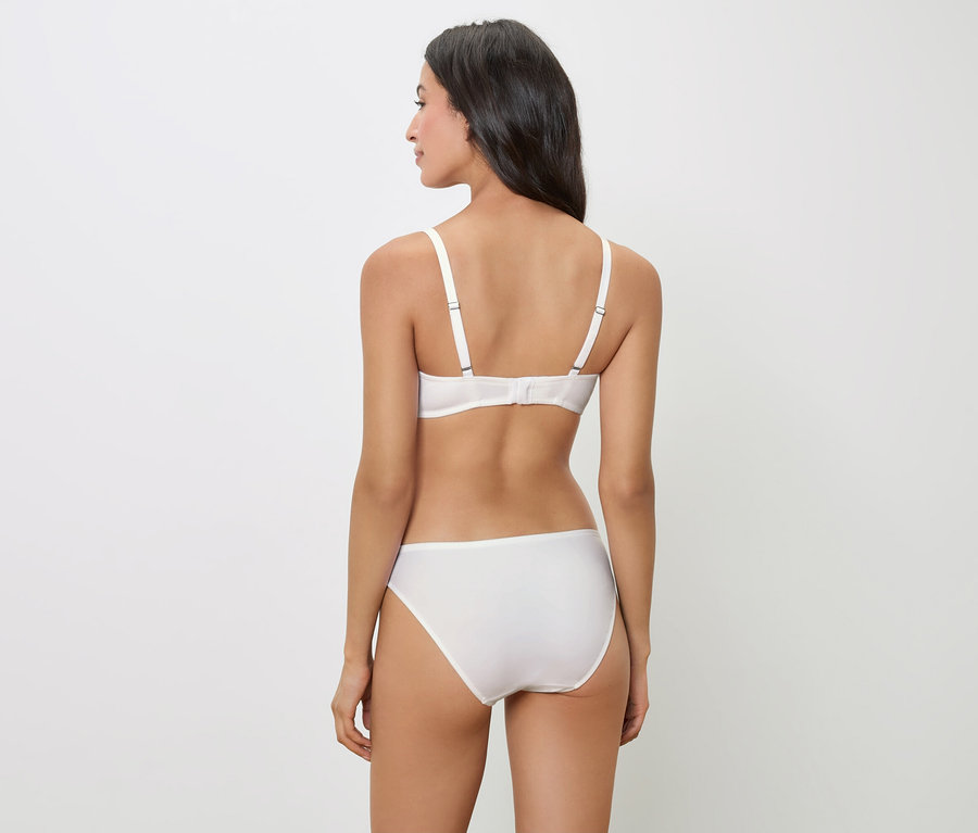 Rückansicht einer Frau mit dunklen Haaren, die einen weißen BH und Höschen trägt.