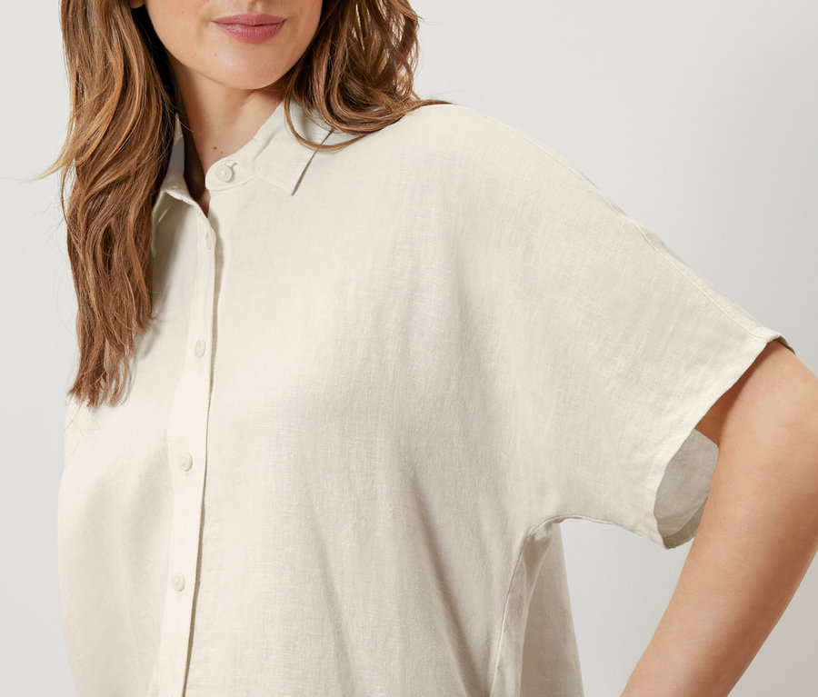 Frau trägt eine cremeweiße Leinenbluse.