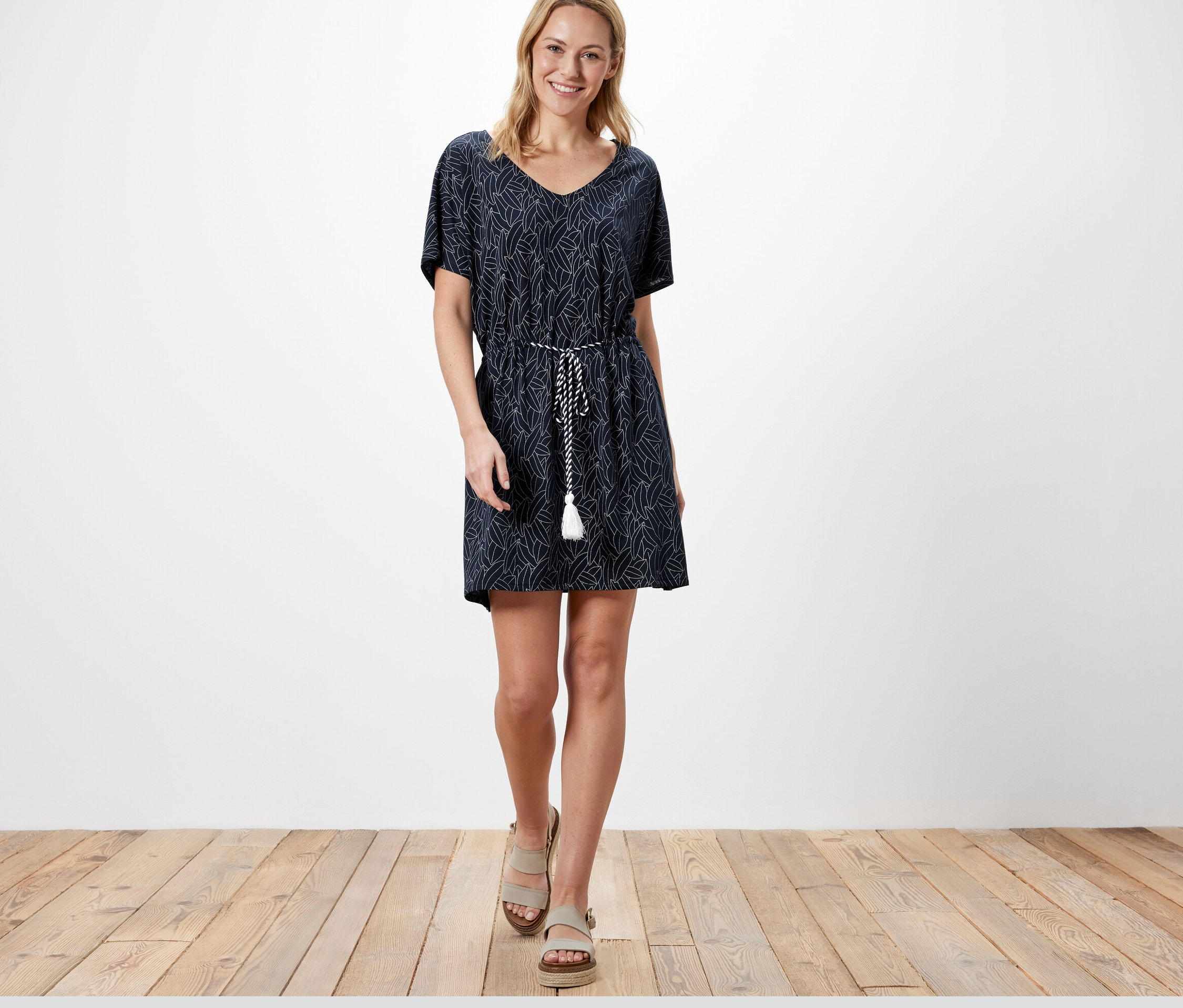 Frau trägt eine Strandtunika und geht.