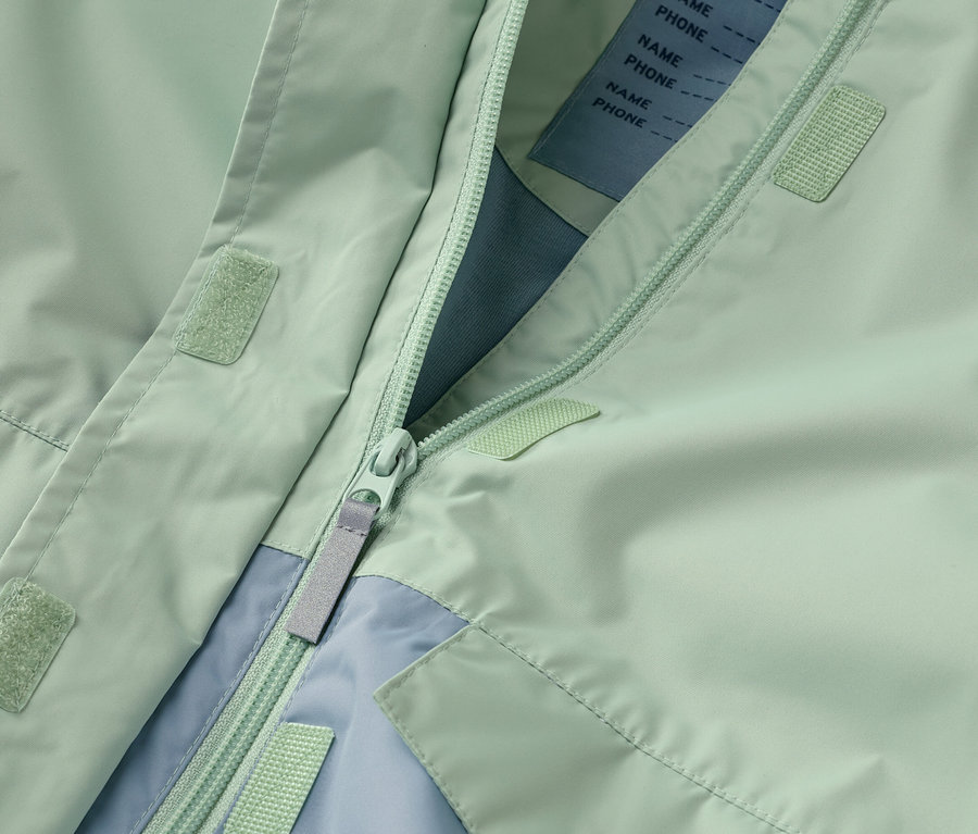 Nahaufnahme einer geöffneten mintgrünen Jacke mit Reißverschluss und hellblauen Akzenten.