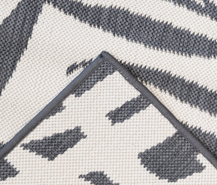 Detailansicht eines grau-weißen Outdoor-Wendeppichs „Palm Tree“.