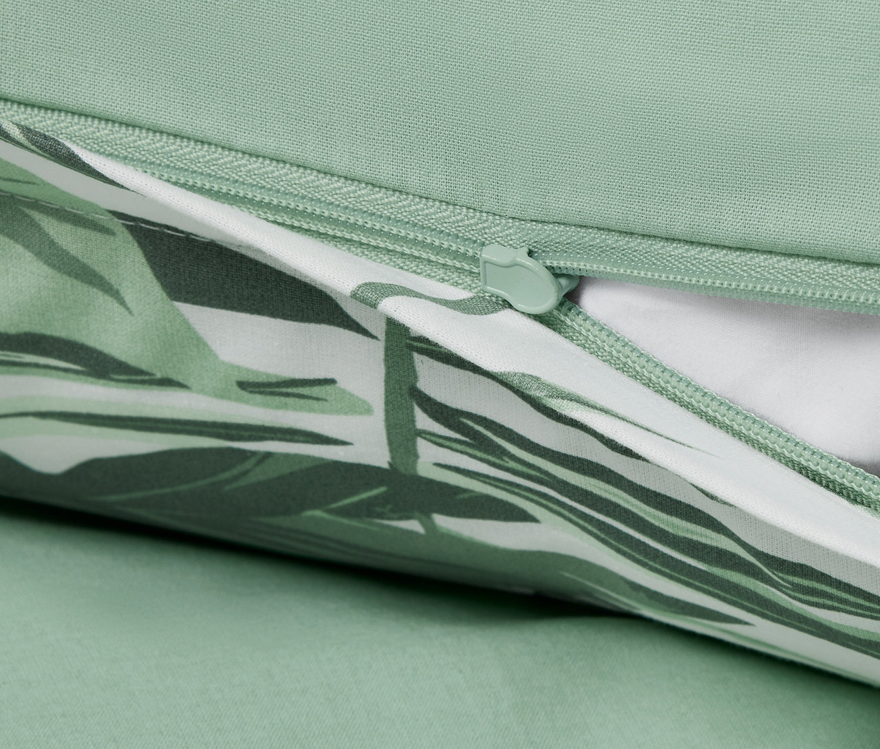 Detail einer Renforcé-Bettwäsche in Normalgröße mit Palmenmuster und Reißverschluss.