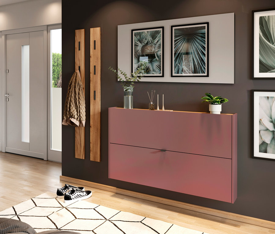 Eingangsbereich mit rosa Schuhschrank, Holzgarderobe, zwei botanischen Kunstdrucken und Schachbrettmuster Sneakern.