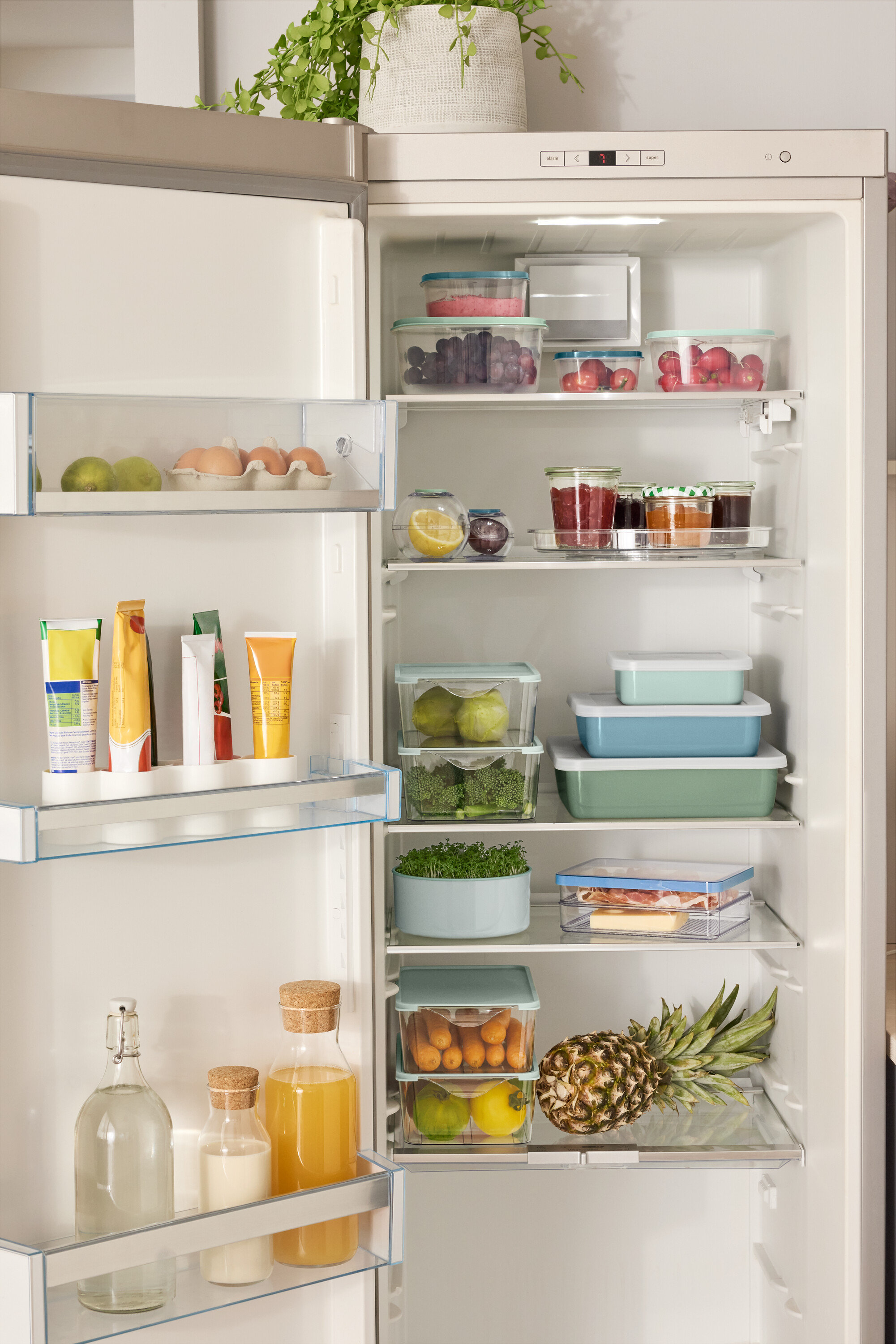 Ein offener Kühlschrank gefüllt mit verschiedenen Lebensmitteln wie Obst, Gemüse und Getränken.