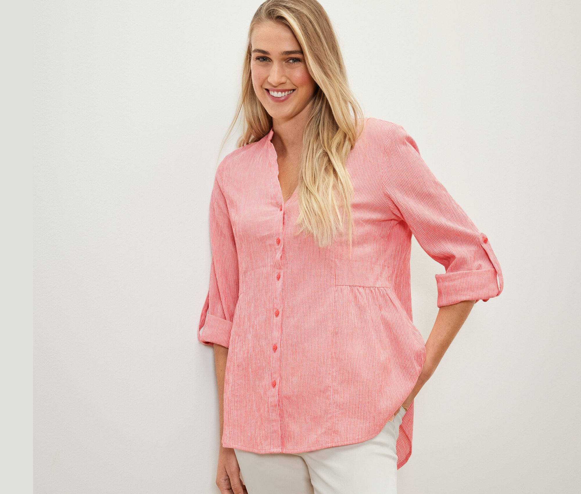 Frau posiert in gestreifter Longtunika, koralle.