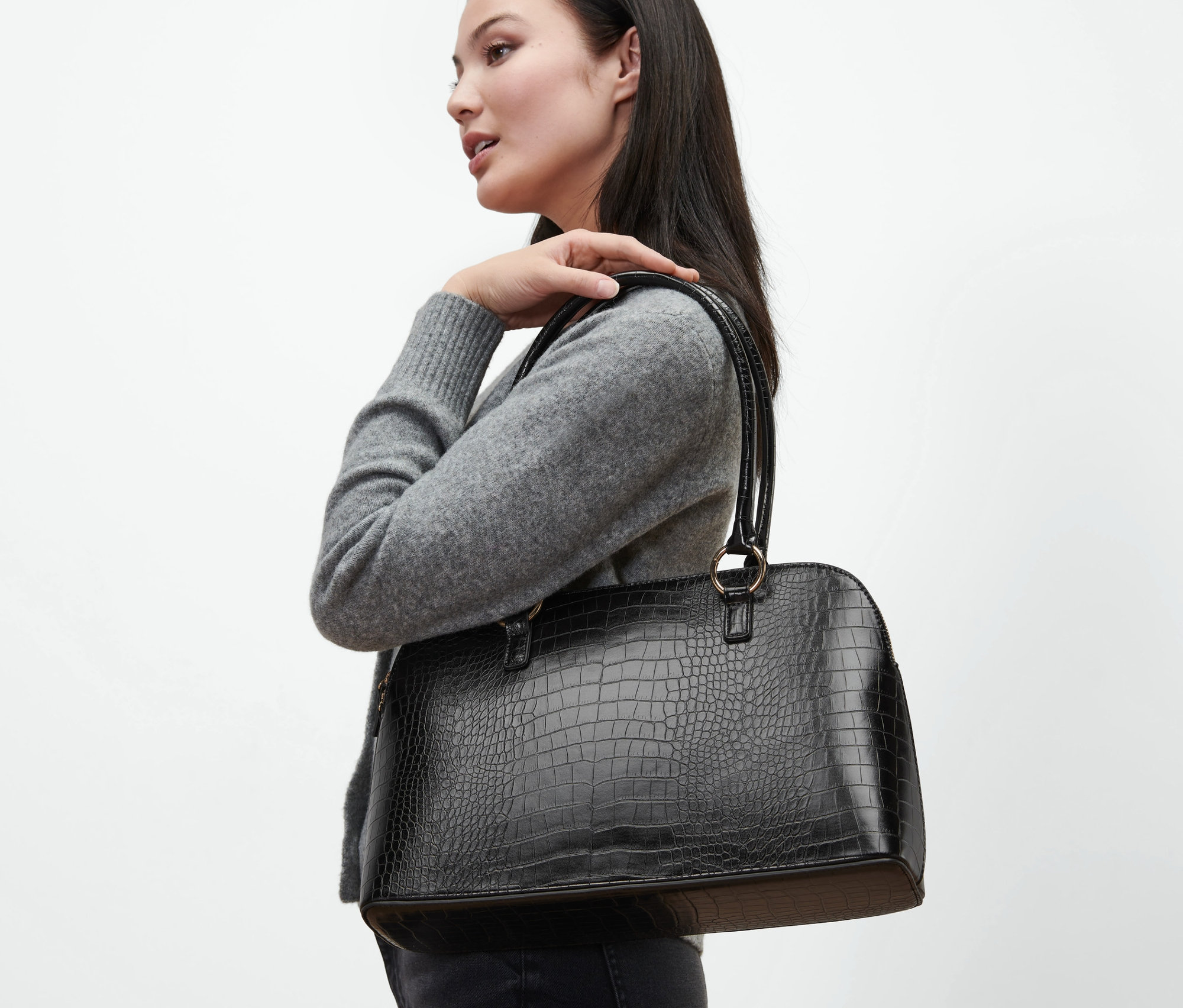 Frau mit schwarzem Shopper über der Schulter.