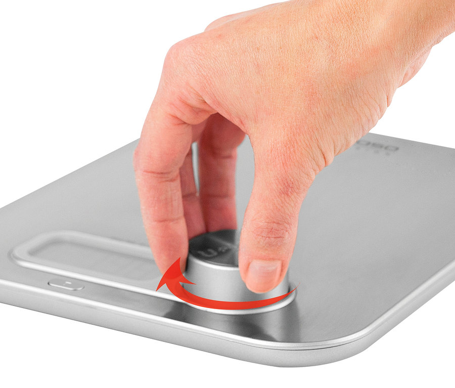 Eine Hand dreht einen Knopf auf einer silbernen CASO Küchenwaage »Kitchen Energy«.