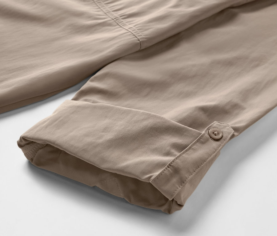 Detailaufnahme eines beigen Outdoorhemdes mit Moskito-Schutz und hochgekrempelten Ärmeln.