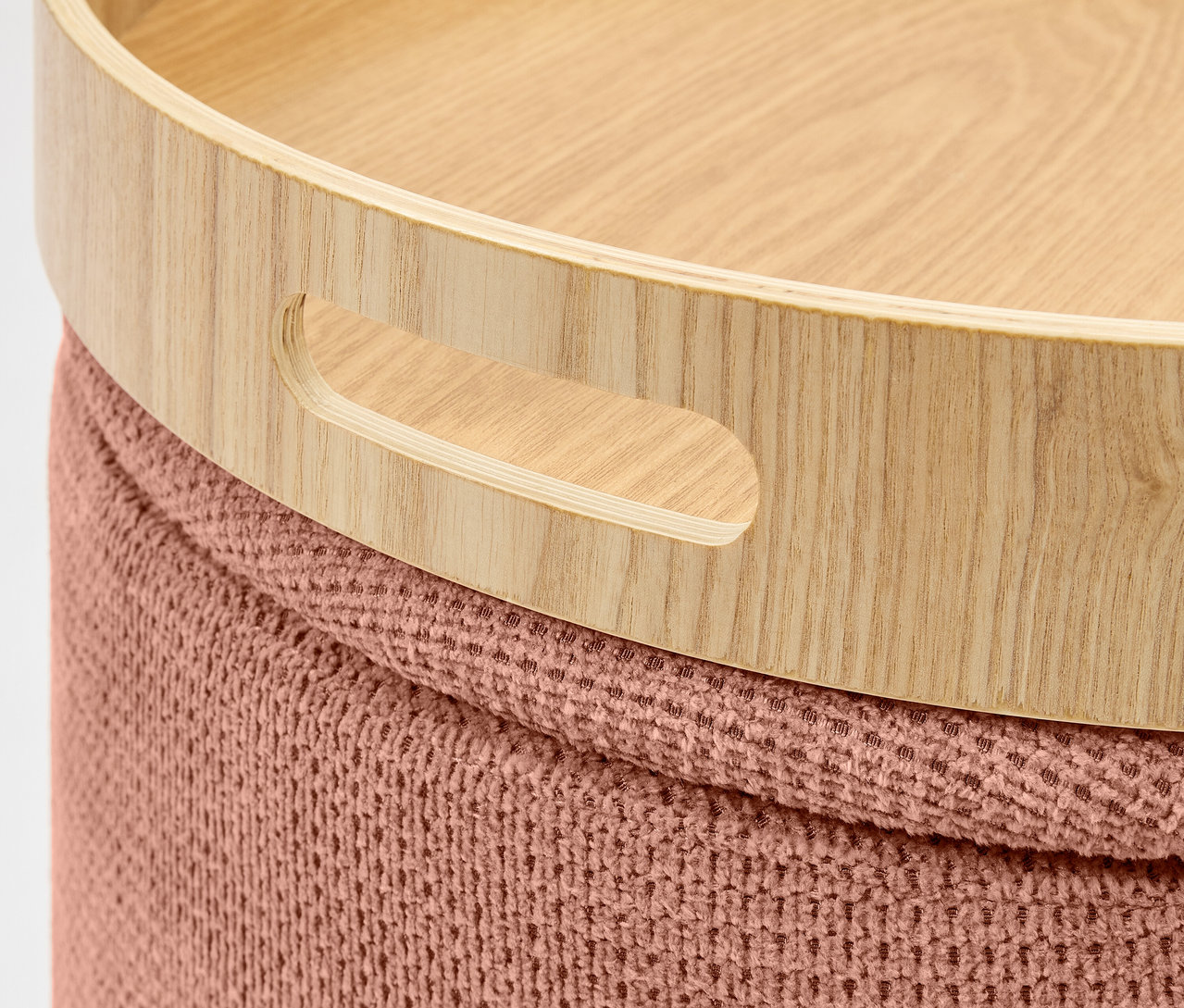 Detailaufnahme eines Holztabletts mit Griffen auf einem gestrickten Hocker.