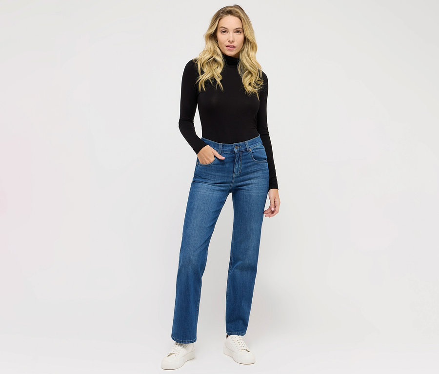 Eine Frau posiert in Angels Jeans »Lara« Straight Fit, mid blue und einem schwarzen Rollkragenpullover.