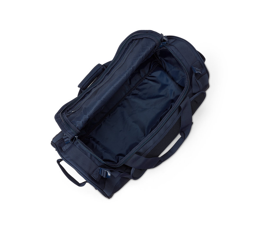 Eine offene, marineblaue Reisetasche und ein Rucksack auf weißem Hintergrund.