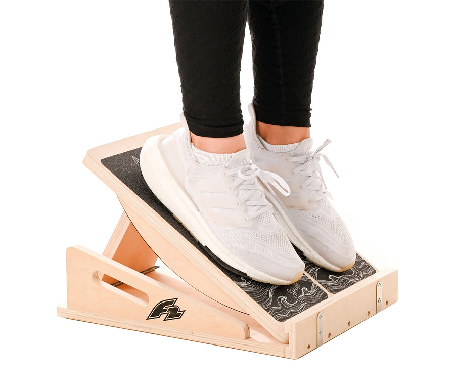 Person steht mit weißen Turnschuhen auf einem F2 Step on Balance Board.