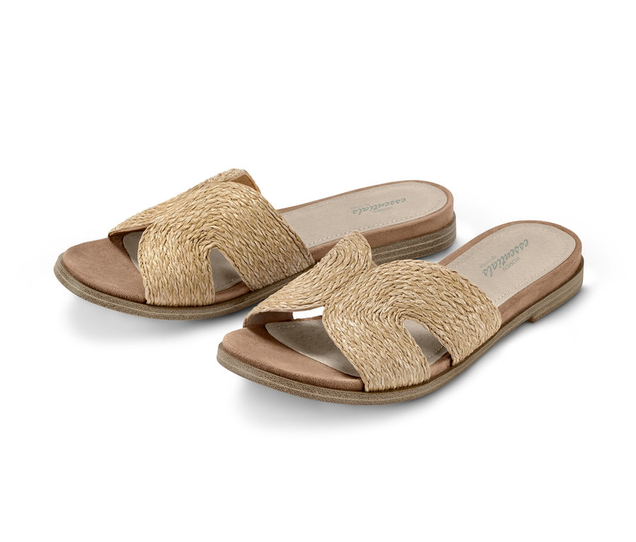 Zwei Pantoletten mit gekreuzten Riemen aus Naturmaterial.