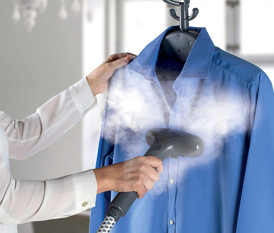 Eine Frau dämpft ein blaues Hemd mit einem Ariete Dampfglätter »Steam Jet Pro«.