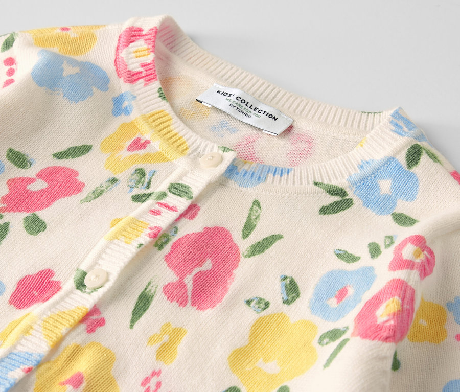 Detailansicht einer Kinder-Strickjacke mit Blumenmuster.