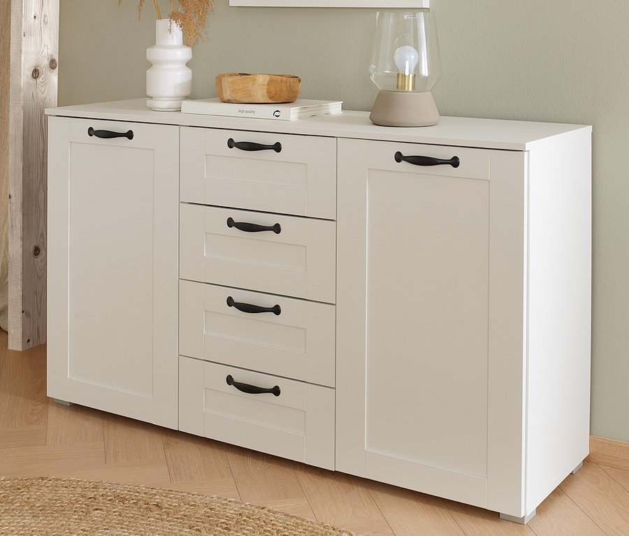 Weiße rauch Kommode »Cottage« mit vier Schubladen und zwei Schränken. Auf der Kommode stehen eine Vase mit Pampasgras, eine Lampe und eine Holzschale.
