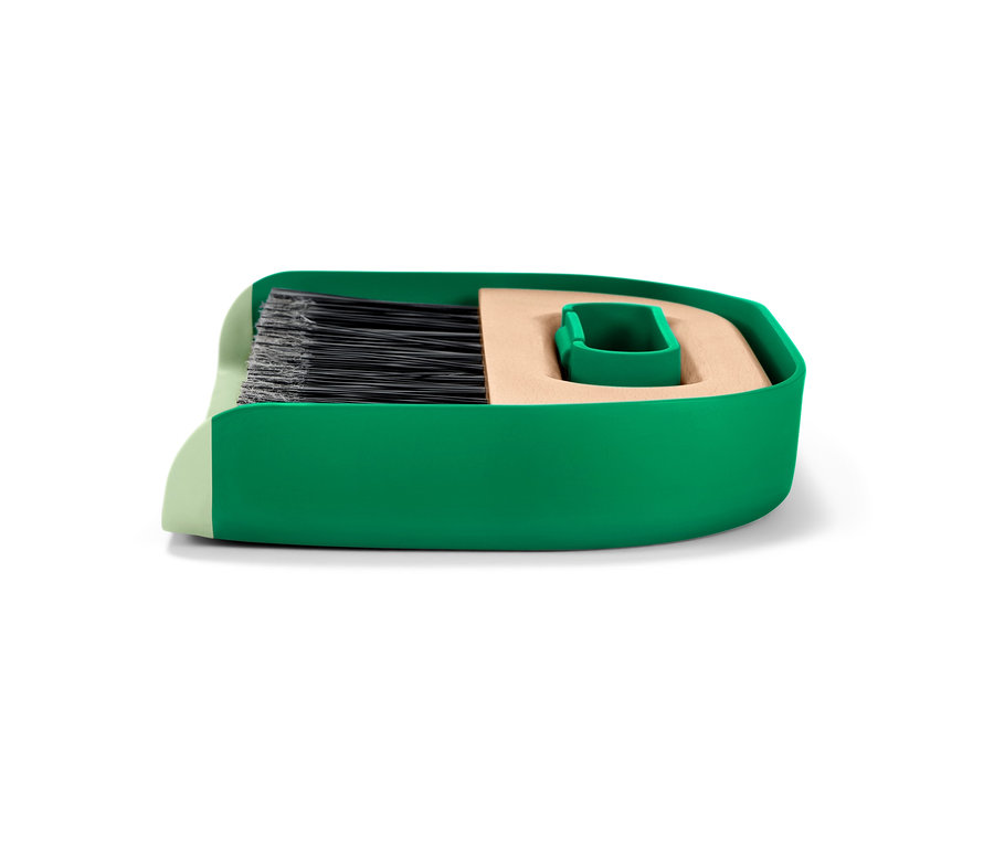 Grüner Handkehrer und Schaufel.