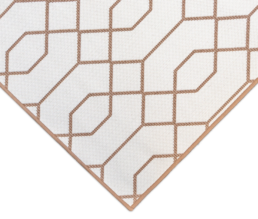Detailansicht eines braunen Outdoor-Wendeteppichs "Geo River" mit geometrischem Muster auf weißem Grund.