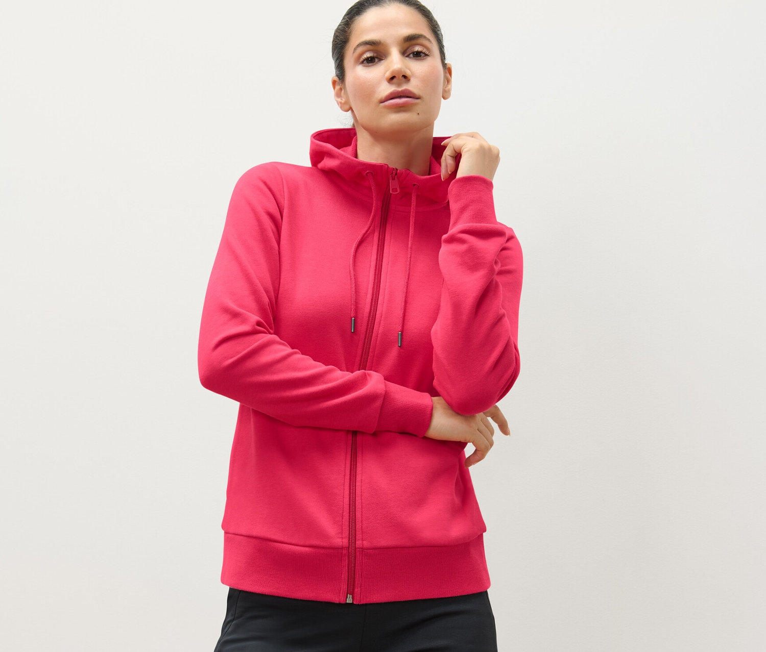 Frau trägt eine pinke Sweatjacke.