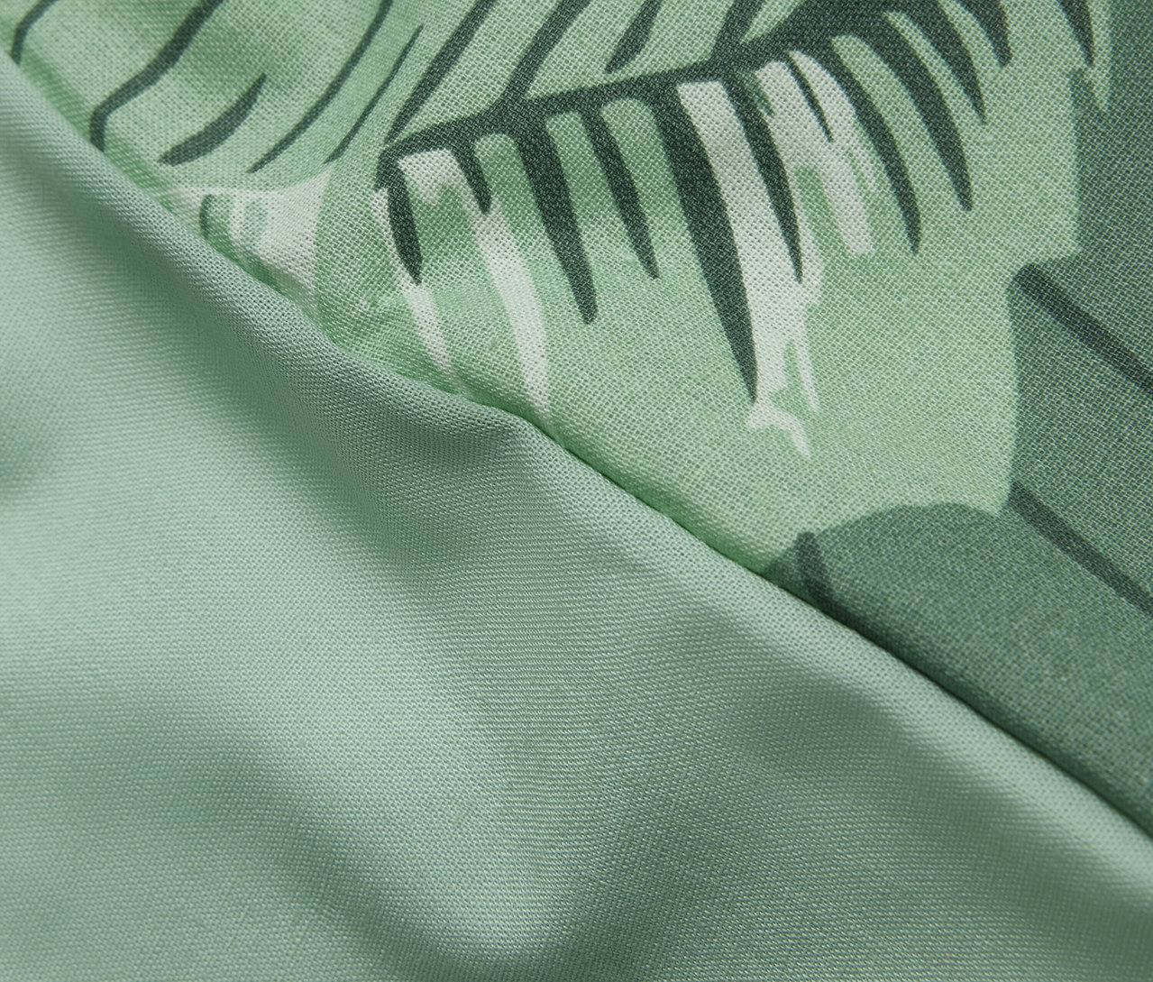 Detail einer Renforcé-Bettwäsche in Normalgröße mit Palmenmuster.