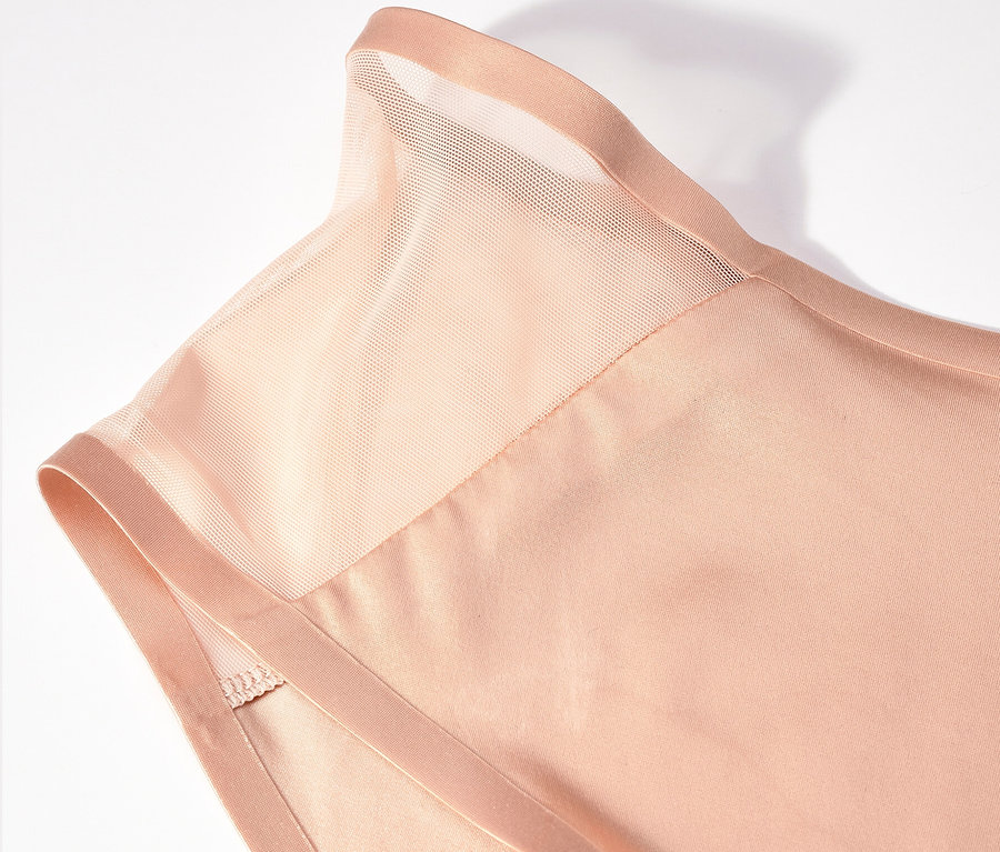 Detailaufnahme eines beigen Oberteils mit transparentem Einsatz an den Schultern.