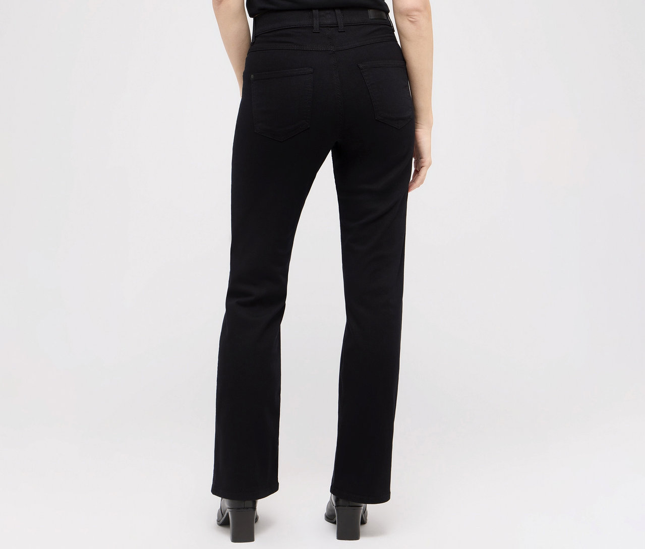 Rückansicht einer Frau in schwarzen Angels Denim »Lara« Straight Fit Jeans und hochhackigen Schuhen.