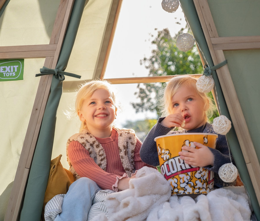Zwei Mädchen sitzen im EXIT Spielhaus Yuki 100 und essen Popcorn.