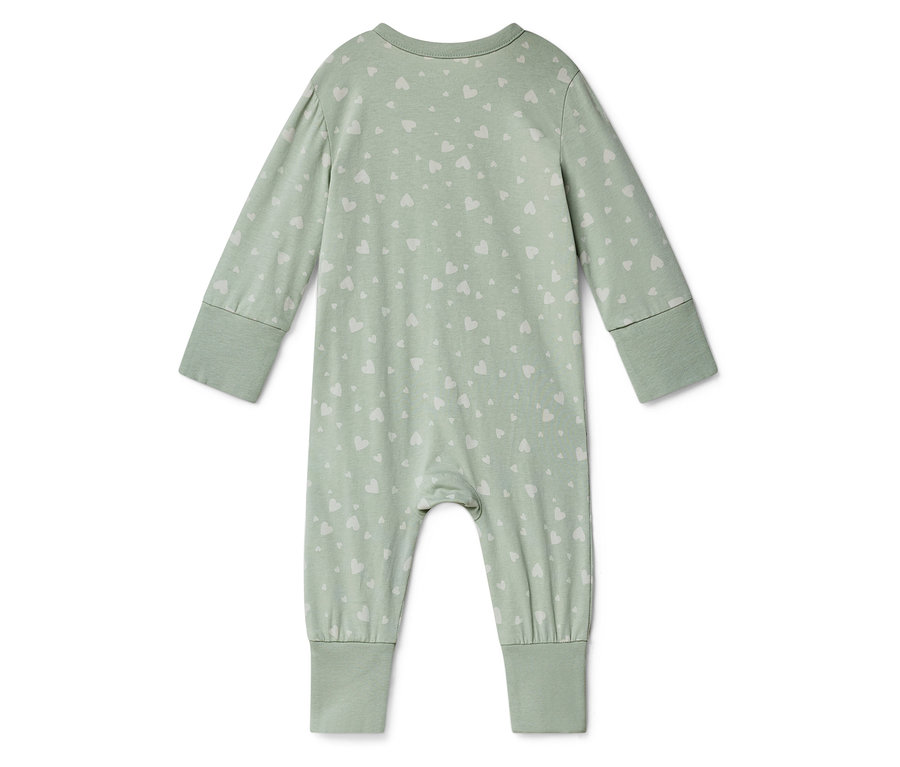 Ein hellgrüner Baby-Strampler mit langen Ärmeln und weißem Herzmuster liegt auf einem weißen Hintergrund.