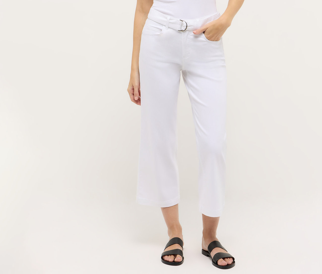 Person trägt eine weiße, geschnittene Angels Denim »Linn City« mit einem silbernen Gürtel und schwarzen Sandalen.