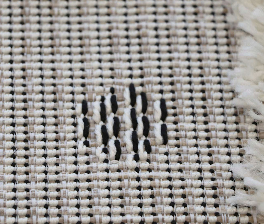 Detailansicht eines Kinderteppichs NAVAJO Lama, ca. 135 x 190 cm, mit beigem Grundmuster und schwarzen Akzenten.