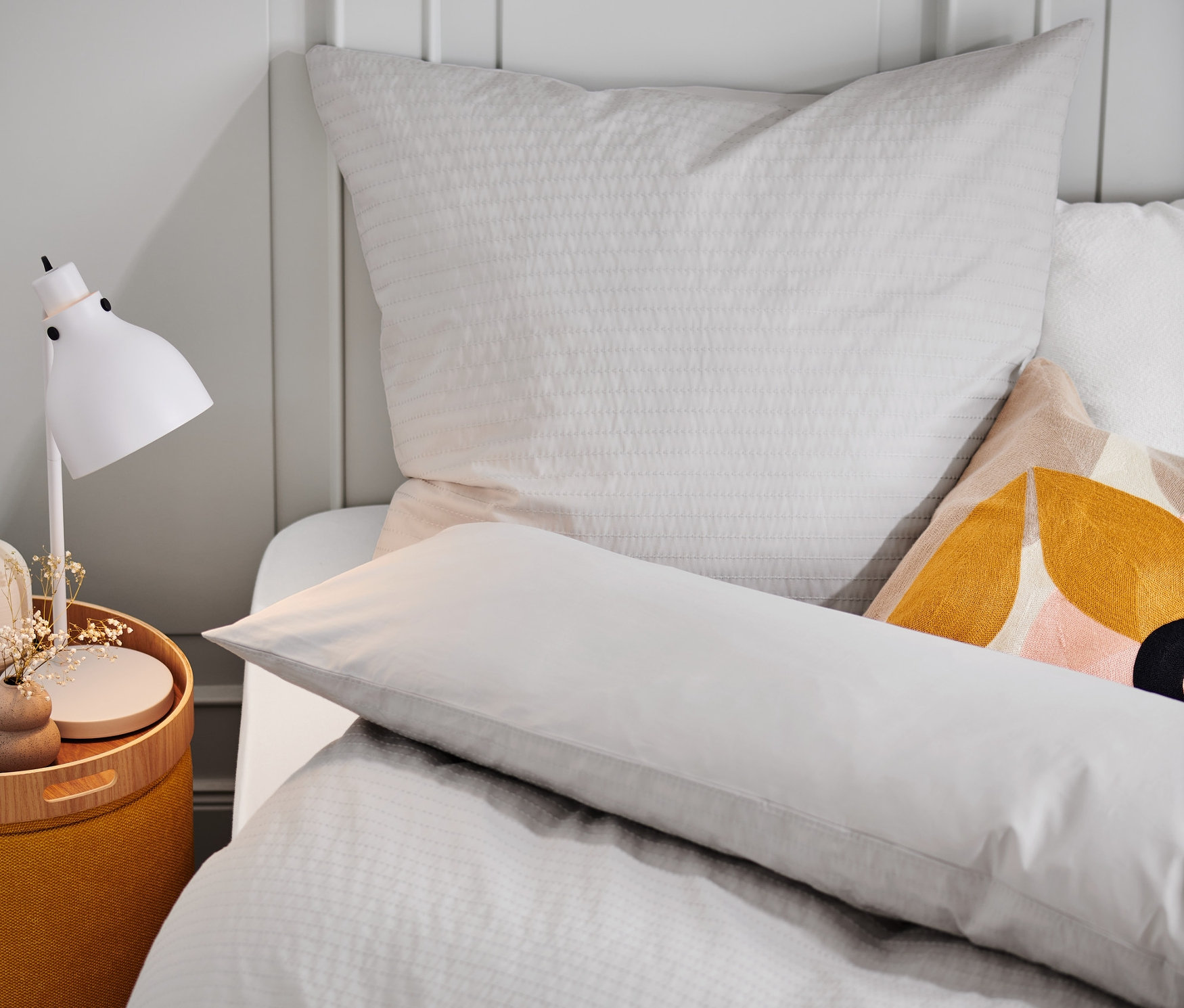 Detailansicht von Premium-Baumwoll-Bettwäsche in Normalgröße auf einem Bett mit Nachttisch.