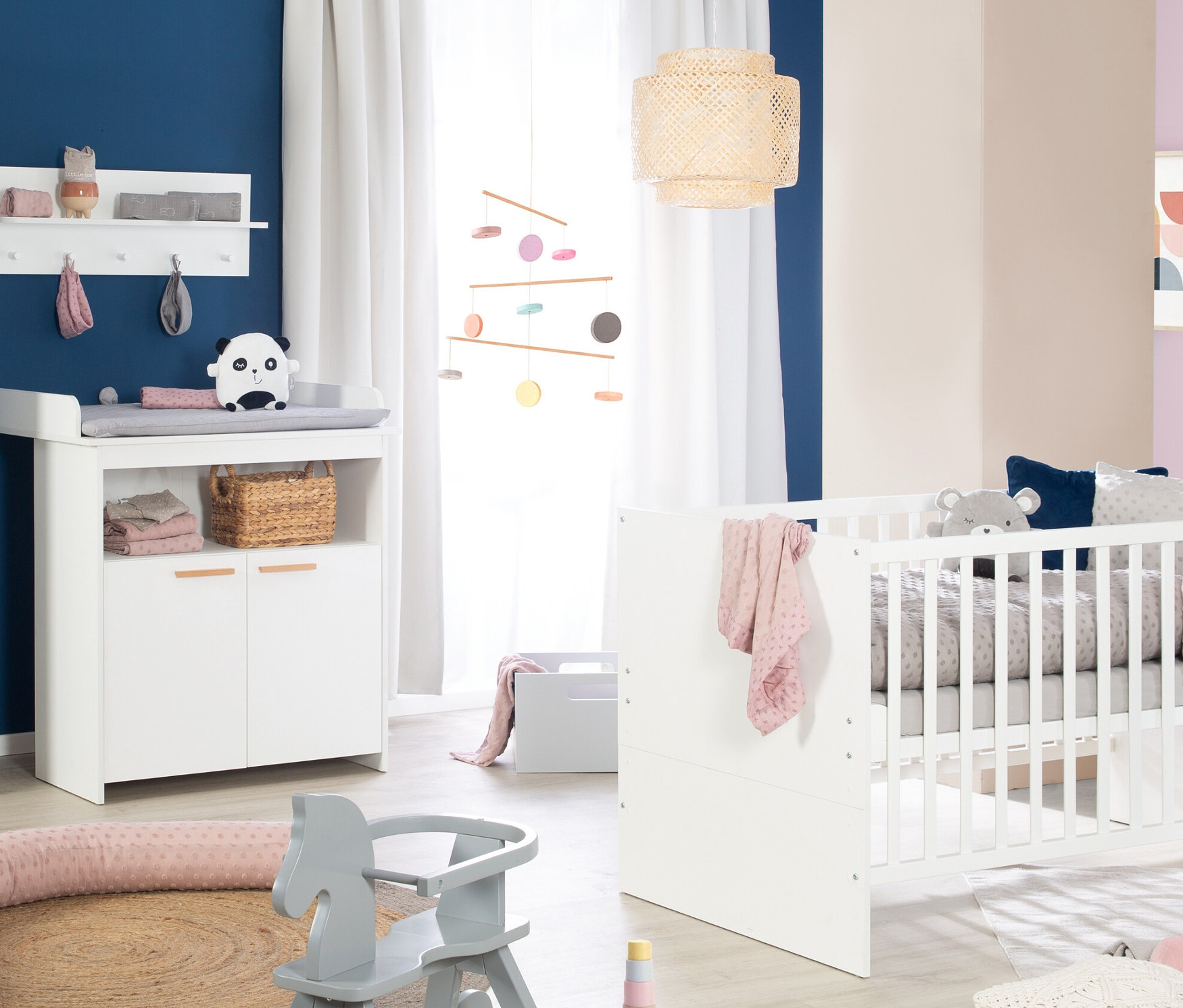 Kinderzimmer mit weißen Kindermöbeln und grauem Schaukelpferd. Zu sehen ist das roba »Anton« Kinderzimmerset mit Bett und Wickelkommode.